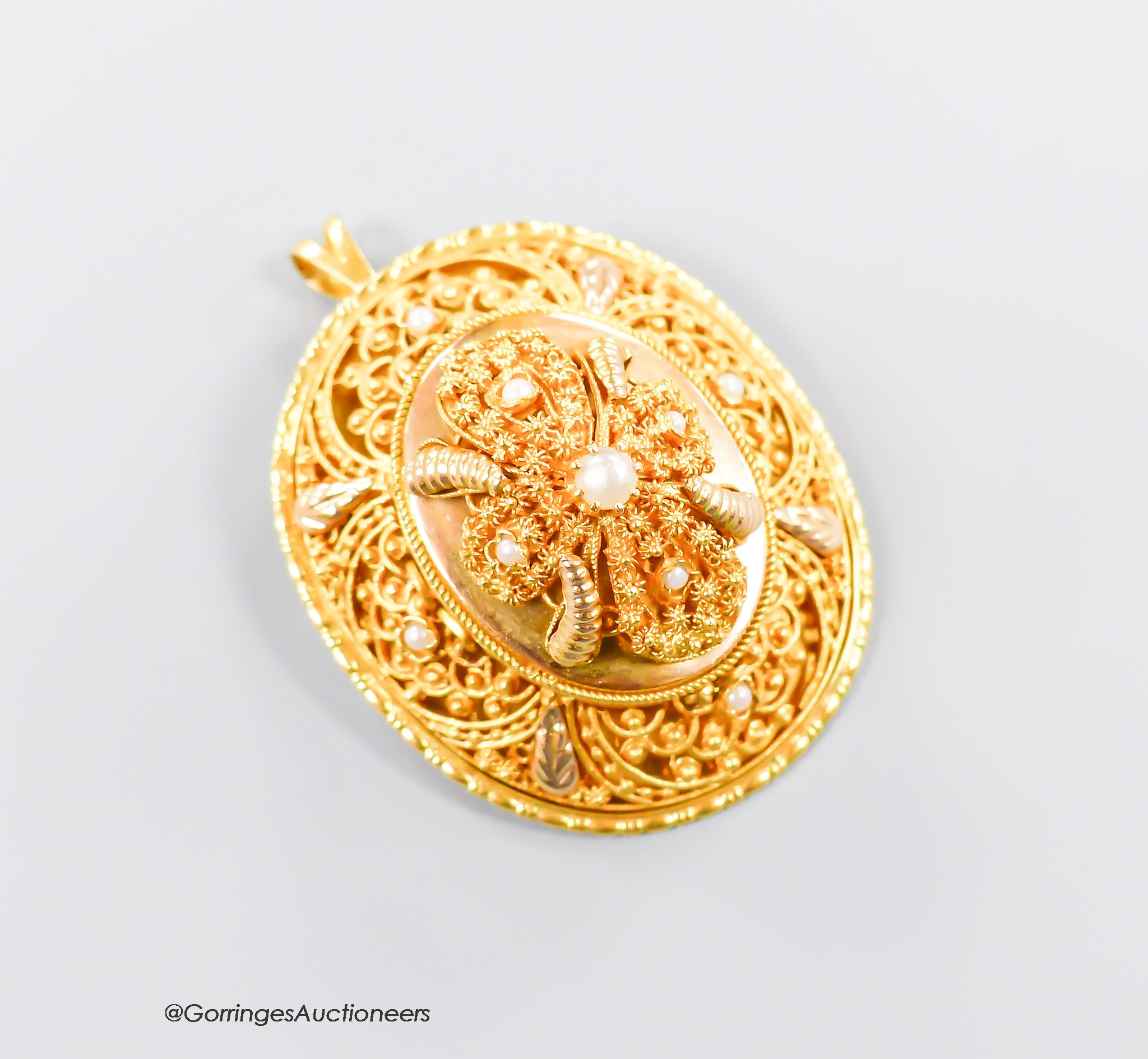 A pierced yellow metal and seed pearl set oval pendant brooch, 40mm, gross 17.9 grams.